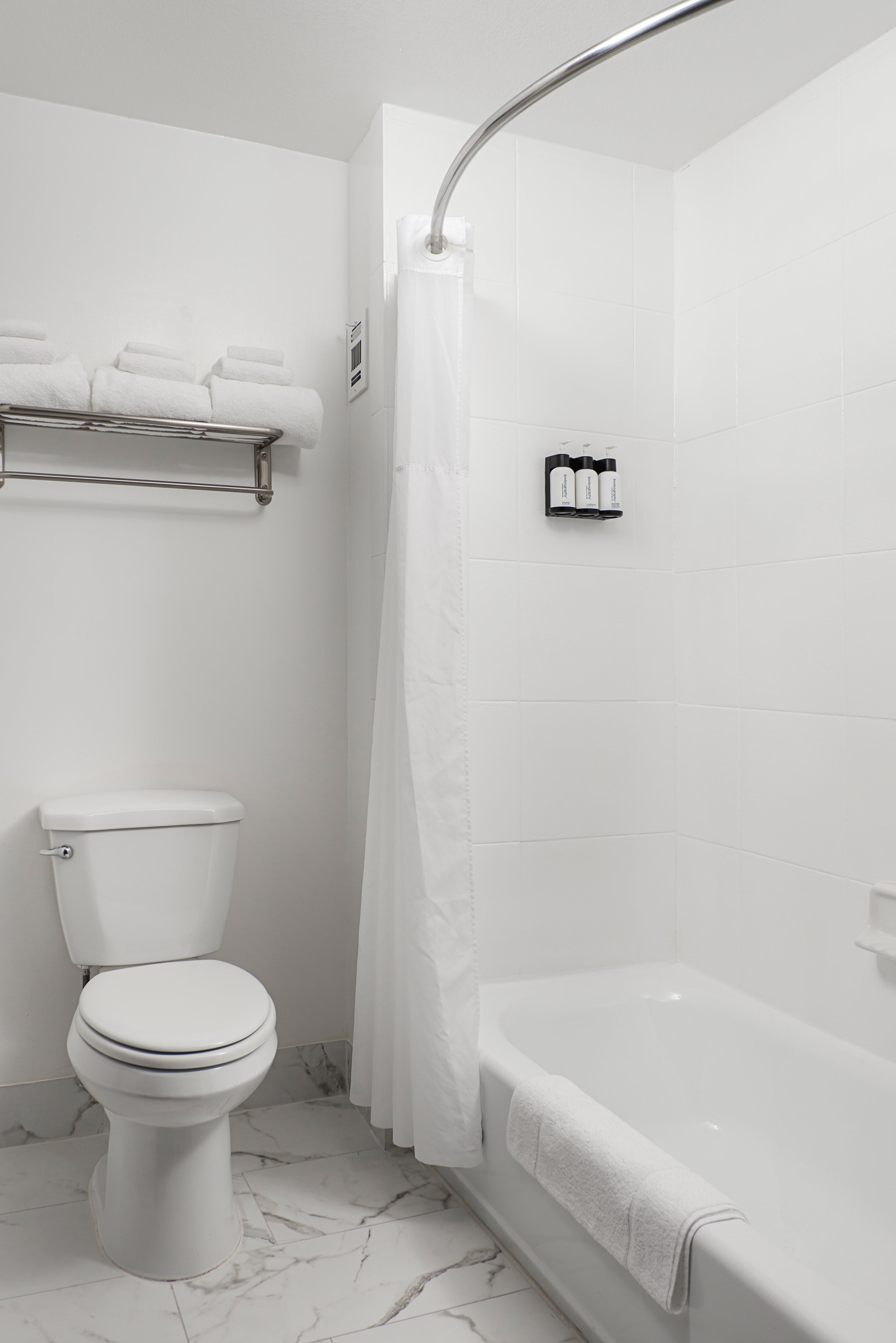 A clean bathroom with a toilet, bathtub, and shower.